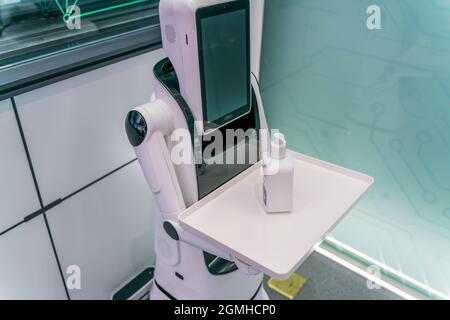 A shot of a robot holding a sanitizer for customers during the covid-19 pandemic Stock Photo