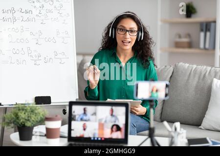 Young teacher giving virtual lecture to diverse students Stock Photo