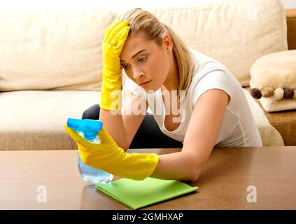 https://l450v.alamy.com/450v/2gmhxap/a-tired-young-woman-fed-up-with-cleaning-her-home-2gmhxap.jpg