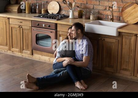 Loving bonding young latin family couple daydreaming at home. Stock Photo