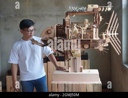 (210919) -- SHIJIAZHUANG, Sept. 19, 2021 (Xinhua) -- Li Zhanlong shows his creation 'Sky Dreamer' at his studio in Luquan District of Shijiazhuang, north China's Hebei Province, Sept. 14, 2021.  Li Zhanlong is a wooden mechanical installation designer in Shijiazhuang. After graduation, Li once worked as a salesman and ran an online shop. In 2018, Li Zhanlong left his job and went to Tianjin to learn carpentry skills.    The wooden mechanical installation consists of a wooden figure and a mechanism device that can make the installation move. By shaking the handle or pressing the button, the ins Stock Photo