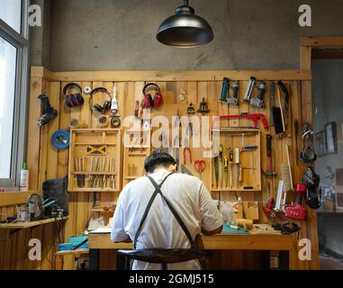 (210919) -- SHIJIAZHUANG, Sept. 19, 2021 (Xinhua) -- Li Zhanlong makes wooden mechanical installation at his studio in Luquan District of Shijiazhuang, north China's Hebei Province, Sept. 14, 2021.  Li Zhanlong is a wooden mechanical installation designer in Shijiazhuang. After graduation, Li once worked as a salesman and ran an online shop. In 2018, Li Zhanlong left his job and went to Tianjin to learn carpentry skills.    The wooden mechanical installation consists of a wooden figure and a mechanism device that can make the installation move. By shaking the handle or pressing the button, the Stock Photo