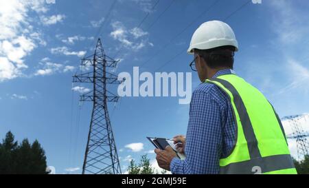 Electrical engineer works by inspecting power lines. Stock Photo