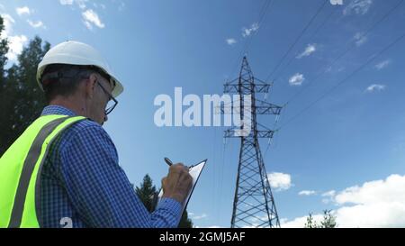 Electrical engineer works by inspecting power lines. Stock Photo