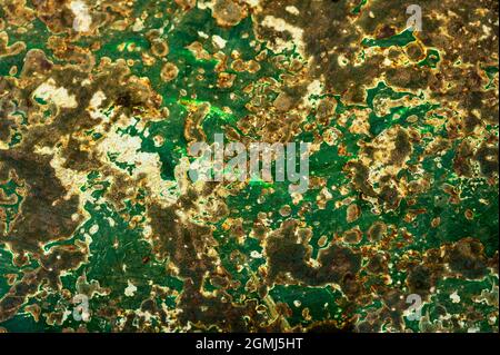 Nice green and yellow abstract pattern, fleck and rust on metallic surface caused by oxidation and corrosion. Painted with green color is peeled. Stock Photo