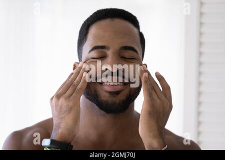 Handsome African man touch face massages smooth perfect skin Stock Photo