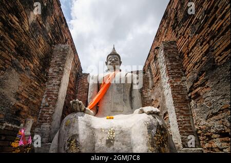 old buddha in old abandoned temple building at archaeological site somewhere in Thailand Stock Photo