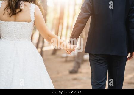 Bride and groom together, and holding hands against to the deep forest view. Wedding concept. High quality photo Stock Photo