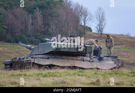 close up of British Army Challenger 2 FV4034 Main Battle Tank crew checking the engine on a military exercise, Salisbury Plain, Wiltshire UK Stock Photo