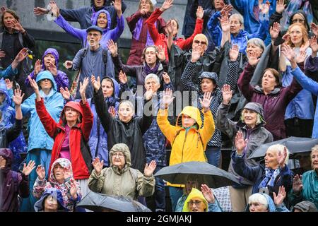 The Scoop, London, UK. 19th Sep, 2021. The singers perform for WaterAid in the pouring rain. Sing for Water celebrates 20 years of raising money for WaterAid as part of Totally Thames festival 2021. Over 30 choirs from around the UK come together for the 20th year to “Sing for Water” and celebrate the River Thames in the incredible riverside setting of The Scoop at City Hall and More London. Credit: Imageplotter/Alamy Live News Stock Photo