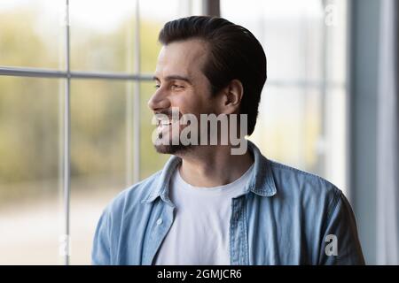 Head shot smiling dreamy man looking in distance, dreaming Stock Photo