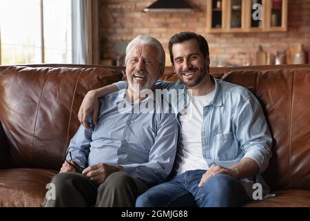 Portrait of happy mature father with grownup son hugging Stock Photo