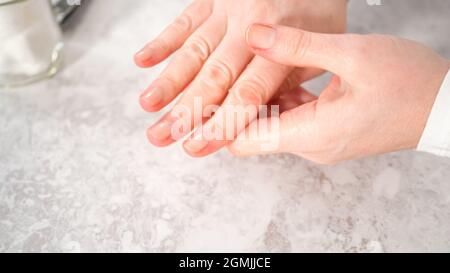 Woman finishing her manicure at home with simple manicure tools