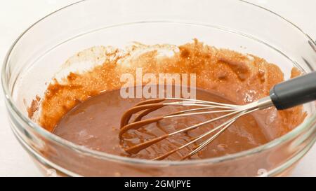Chocolate muffin batter in a glass bowl close up on white background Stock Photo
