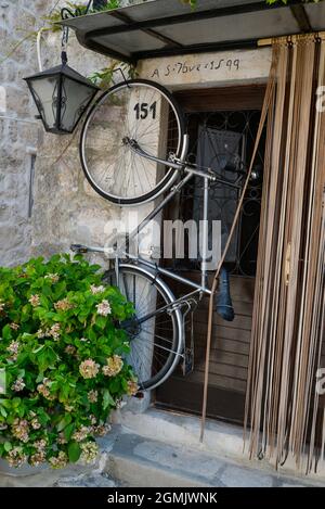 An old bicycle hangs in the doorway of a typical Montenegrin traditional,stone built house. Stock Photo