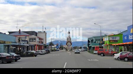 A view down Weld Street in Hokitika, New Zealand, includes the landmark clocktower at the Sewell roundabout.  Founded in 1864, Hokitika, located on the west coast of the south island, attracted people during the gold rush and now attracts tourists. Stock Photo