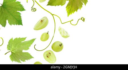 Falling green grape with leaves, isolated on white background, selective focus Stock Photo