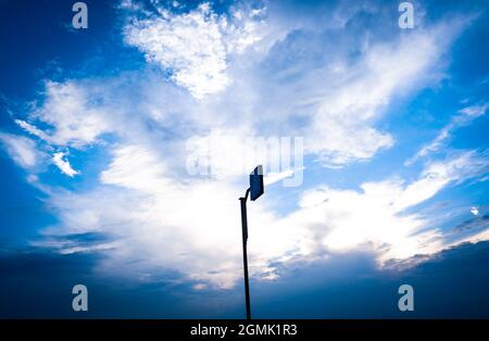 Signpost on a pole against bright blue partly cloudy background Stock Photo