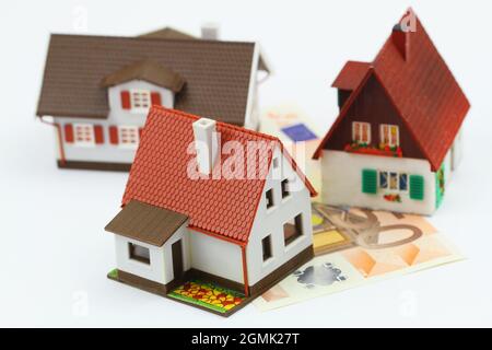 Concept of mortgage loan: model houses on British pound banknote on white background Stock Photo