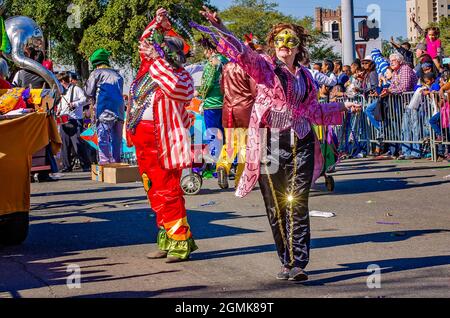 A woman throws Mardi Gras beads during the Joe Cain Day Mardi Gras parade, Feb. 26, 2017, in Mobile, Alabama. Stock Photo