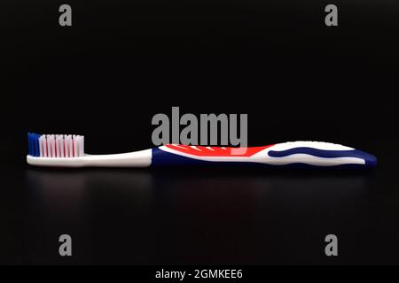 Red and blue toothbrush over black background Stock Photo
