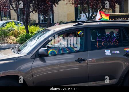 Participants wave from a car with a banner that says 'Love is love,' 'Black Lives matter' and more participate in a Placer County Pride caravan event Stock Photo