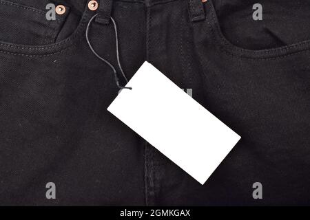 black price tag on black denim jeans, tag on denim for advertisement and message Stock Photo