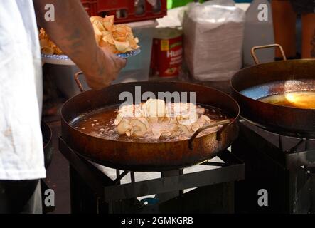 A worker in a festival food booth cooks ribbon fries in large pans of oil at the annual Fiesta de Santa Fe in Santa Fe, New Mexico. Stock Photo