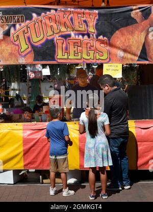 Customers purchase smoked turkey legs from a food vendor at the annual Fiesta de Santa Fe in Santa Fe, New Mexico. Stock Photo