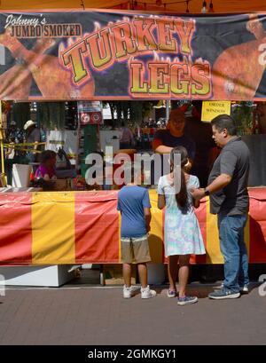 Customers purchase smoked turkey legs from a food vendor at the annual Fiesta de Santa Fe in Santa Fe, New Mexico. Stock Photo