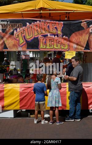 Customers purchase smoked turkey legs from a food vendor at the annual Fiesta de Santa Fe in Santa Fe, New Mexico. Stock Photo