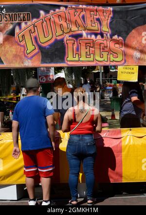 Customers purchase smoked turkey legs from a food vendor at the annual Fiesta de Santa Fe in Santa Fe, New Mexico. Stock Photo