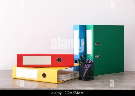 Office folders and holder with stationery on light background Stock Photo