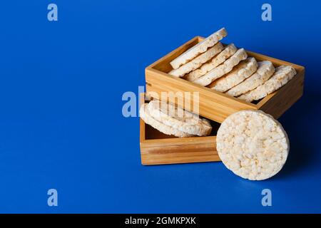 Wooden boxes with crispy rice crackers on color background Stock Photo