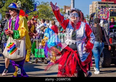 A woman throws Mardi Gras beads during the Joe Cain Day Mardi Gras parade, Feb. 26, 2017, in Mobile, Alabama. Stock Photo