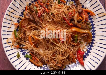 aerial view of a rice noodle wok dish with vegetables with soy sauce. traditional asian food. horizontal