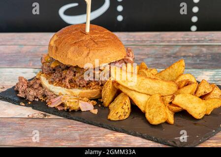 Shredded pork burger with bacon, melted cheese, crispy onion and French fries Stock Photo