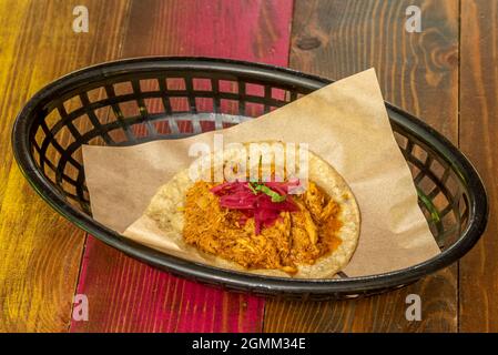 tray with a Mexican taco of cochinita pibil with purple onion on a corn tortilla Stock Photo
