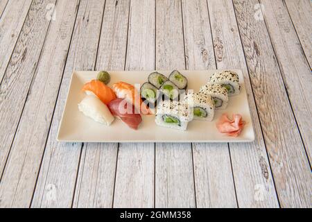 Assorted sushi platter with uramaki california roll with avocado and nori seaweed, seaweed maki, shrimp nigiri, butterfish and salmon marinated with b Stock Photo