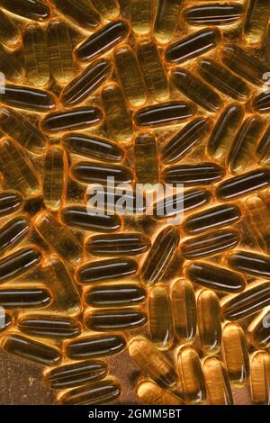 Fish oil capsules close-up on a gold background .omega fatty acids.Natural supplements.Healthy eating and food supplements.Natural supplements  Stock Photo