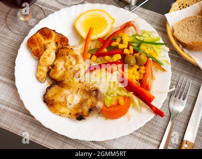 Oven baked hake with vegetable garnish Stock Photo