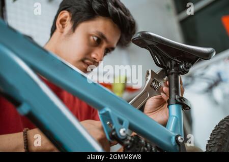close up of a mechanic installing and tightening seatpost screws using a wrench Stock Photo