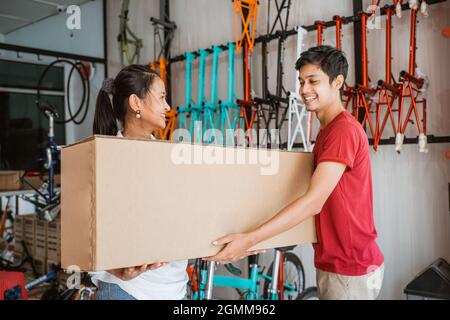 customer buying new bicyle in a box from shop owner Stock Photo