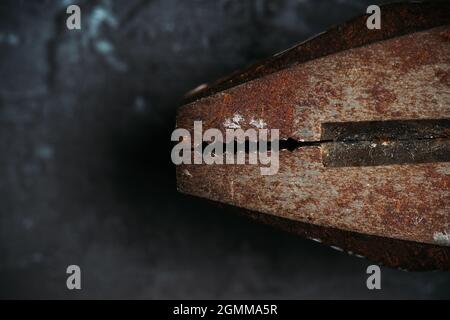 Old rusty pliers on the gray concrete background. Macro shot. Selective focus. Shallow depth of field. Stock Photo