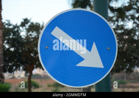 Pass designated place on right. Blue road sign Pass on This Side with white arrow pointing to the right. Mandatory signs. Road signs in Israel Stock Photo