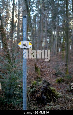 sign post for hikers in the forest. two drawn people with yellow and white arrows pointing to the right and left Stock Photo
