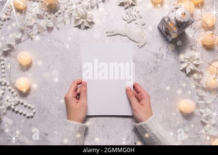 Female hands are holding a Christmas card. Festive atmosphere during Christmas time. Stock Photo