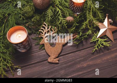Christmas composition in brown. Fir branches candle and decorations on wooden table. Stock Photo
