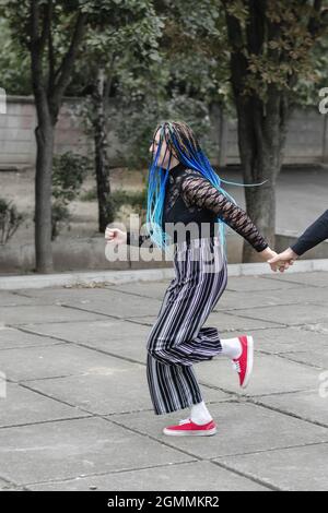 The happy woman runs holding the man's hand. A young adult runs Stock Photo