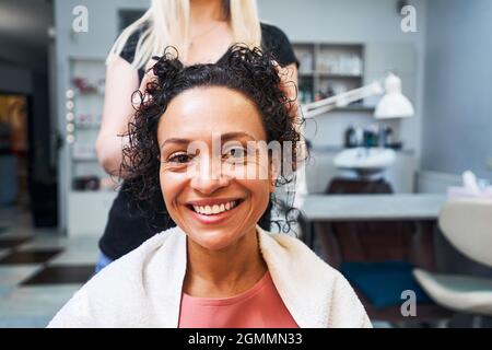 Delighted client enjoying procedure for curly hair Stock Photo